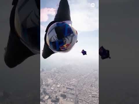 Wingsuit flyers perform daring between-tower stunt