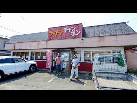 Working Japanese men eat a lot of big yakisoba noodles and fried chicken at roadside.